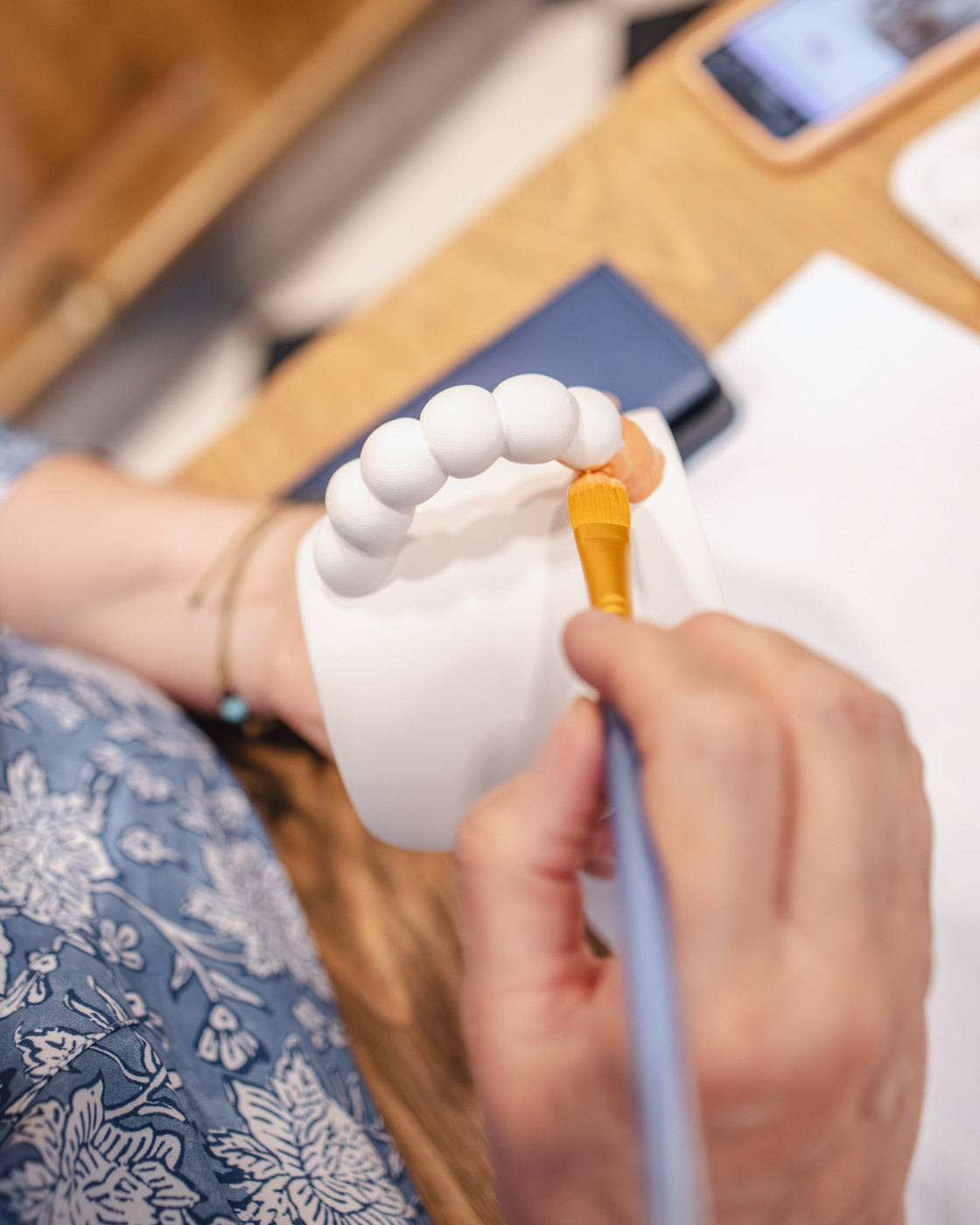 Cliente peignant une tasse en céramique dans un atelier